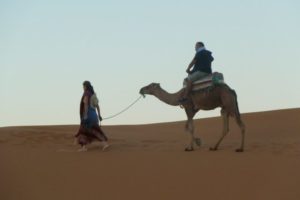 Riding a camel in the Sahara, Morocco