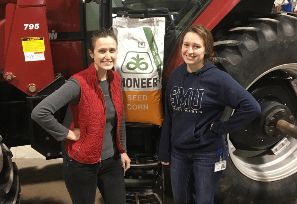 sisters standing in front of tractor