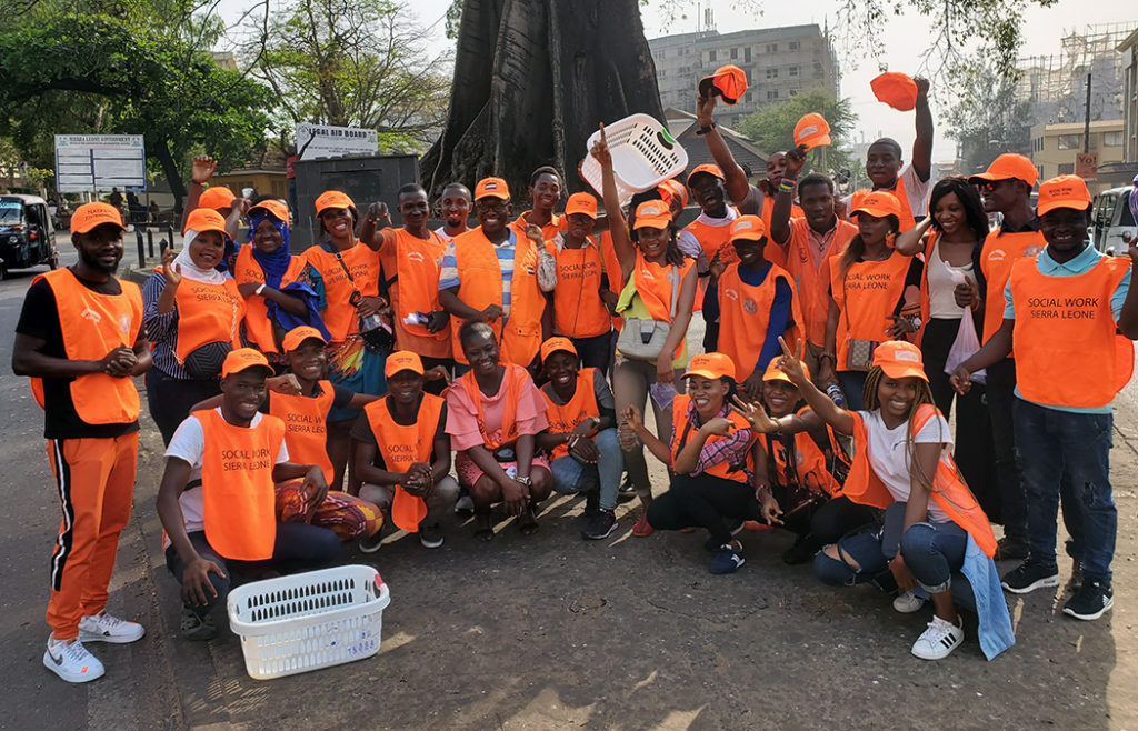 Members of Social Workers Sierra Leone take a group photo clad in their bright orange gifts, which were donated from Sylvester Amara Lamin, associate professor of the MSW program.